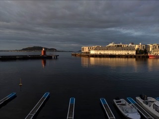 Harbour at dusk with moored boats under a heavy sky