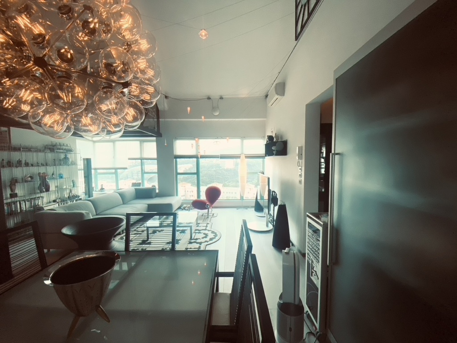Loft living room with a glass bubble chandelier and floor-to-ceiling windows