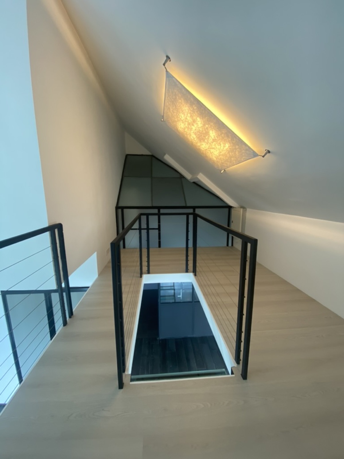 Mezzanine landing with black steel balustrade and fabric ceiling light